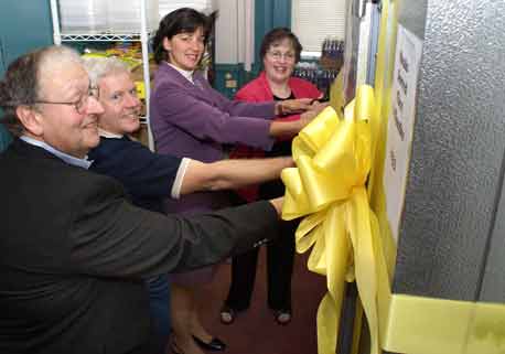 Deacon Gil Nadeau, Electrician Rich Vogel, West Side Kitchen's Bonnie Woods and Jan Squadrito of the Community Foundation cut ribbon on walk-in freezer.
